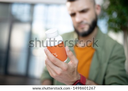Holding sleeping pills. Close up of man holding pack with sleeping pills while suffering from insomnia