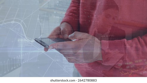Holding smartphone, man in red sweater analyzing market charts at desk, with data overlays. Financial, technology, digital, analytics, professional, business, data visualization
