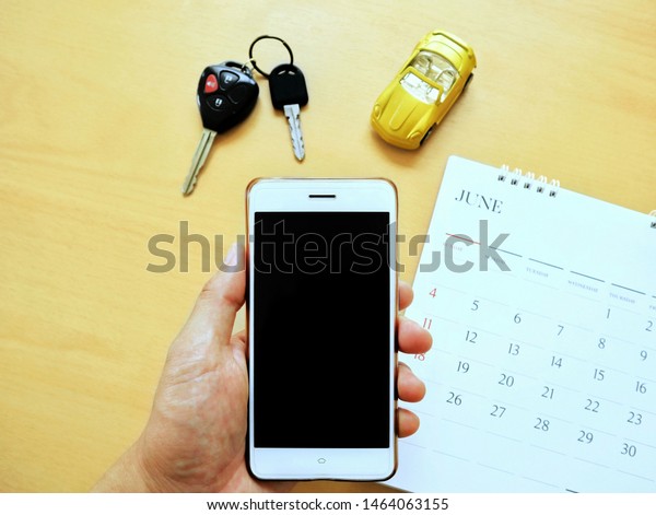 Holding the\
smartphone on hand for checking car service schedule and\
appointment via mobile\
application.