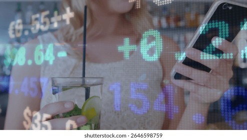 Holding smartphone and sipping mint lime cocktail at bar counter, showing floating numeric overlays. Cocktail, technology, modern, nightlife, social, digital, leisure
