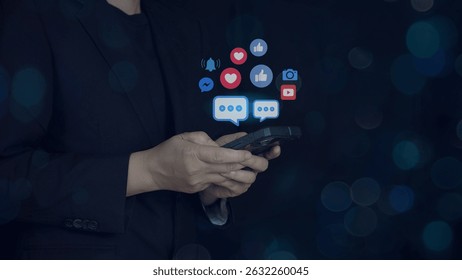 holding smartphone with social media icons like thumbs up, chat bubbles, heart, and user groups. digital marketing, interaction,Social Media Network Engagement and Online Communication Concept.