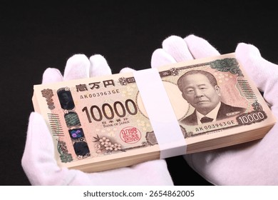 Holding a stack of bills in white gloves. Translation:10000 yen, Bank of Japan note, Bank of Japan, produced by the National Printing Bureau.