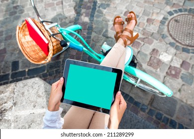 Holding tablet in the hands with bicycle on background in the city - Powered by Shutterstock