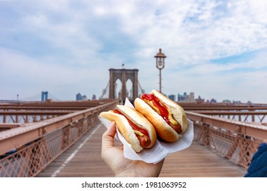 Holding two hot dogs in NYC on the Brooklyn Bridge . - Powered by Shutterstock