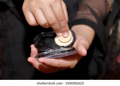 Holding and using makeup foundation kit.