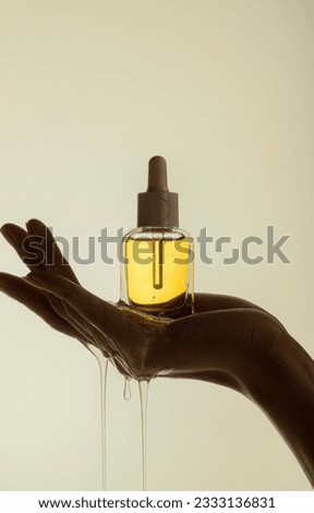 Holding yellow transparent skin care product essence backlight