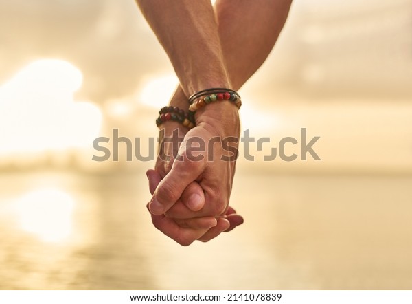 Holding your hand while we wonder the beach.\
Closeup shot of an unrecognizable couple holding hands while\
spending the day by the\
beach.