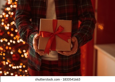 holds in his hand a box with a gift for Advent holiday.  Happy New Year and Merry Christmas