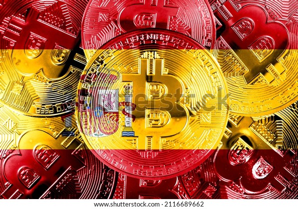 Holds a physical\
version of Bitcoin and the Spanish flag. Concept map of\
cryptocurrency and blockchain technology in Spain. Double exposure\
creative bitcoin symbol hologram.\
