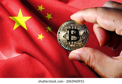 Holds The Physical Version Of Bitcoin (the New Virtual Currency) And The Chinese Flag. Chinese Cryptocurrency And Blockchain Technology Investor Concept Map