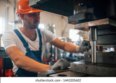 Holds slice of metal. Man in uniform works on the production. Industrial modern technology. - Shutterstock ID 1445205602