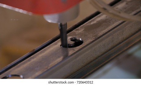 Hole being drilled into metal. Drilling closeup in metal workshop. Employee drill in flat steel plate with bench drill. Industry in slow motion