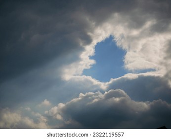 hole of blue sky in dramatic clouds