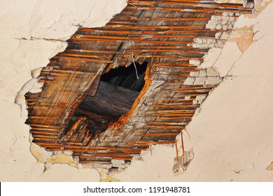 hole in the ceiling after fungus attack, decay on plaster and wooden structure due to water infiltrations