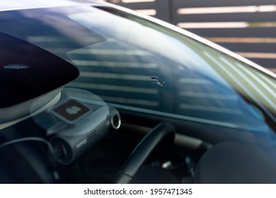 A Hole In The Center Of The Windshield Made Of Stone From The Wheels Of The Car In Front.