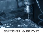 The hole chamfering process on NC milling machine with drill tools in the light blue scene.  The metal working concept on the milling machine.