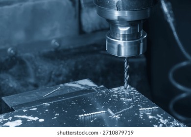 The hole chamfering process on NC milling machine with drill tools in the light blue scene.  The metal working concept on the milling machine.