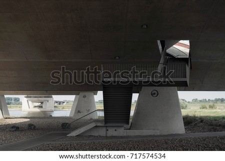 Hole in concrete bridge with stairwell going through.