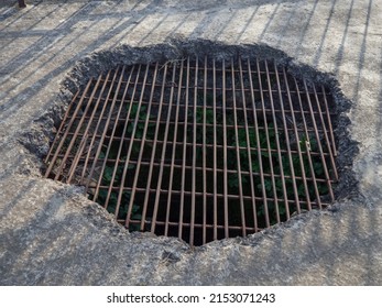 A Hole In The Concrete Floor Covered With Grating. Trap. Cell In The Dungeon. 