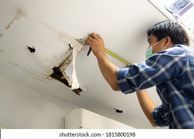 Hole damaged in ceiling house from pipes water leakage with worker repair and fixing ceiling panels. Office building or house problem from plumber system repairman service concept.