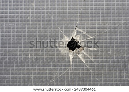  Hole in a destroyed safety glass window                              