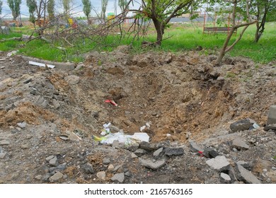 A hole in the ground from a cannon explosion of a Russian shell in the Kharkiv region in Ukraine 2022. A shelling crater.