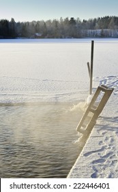 Hole In The Lake Ice For Ice Swimming. Pump Visible Towards End Of Jetty Keeps Water Open. Footprints And Ski Tracks Visible. The Temperature Is Below -20 C Creating A Particular Atmosphere