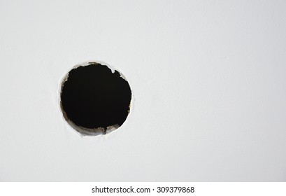 Hole on the white wall. Picture can be used as a background   