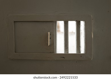 a hole in the prison door made of gray iron - Powered by Shutterstock