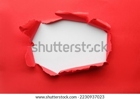 Hole in red paper on white background