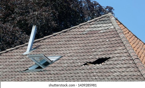 Hole In The Roof Of A Residential Building. Repair Of A Tile Roof After A Storm Damage.
