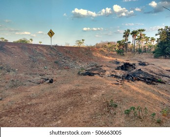 a hole at the side of the highway in a devastated field