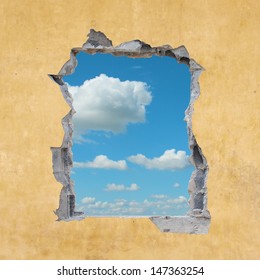 A Hole In A Wall With Blue Sky