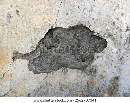 Hole in the wall, surface with big cracks and crumbling plaster, the old wall of a house