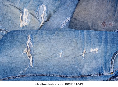 Hole And Worn Places In The Different Old Torn Jeans Showing The Frayed Threads And Fabric Texture, Fragment 
