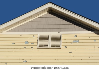 Holes In Exterior Siding In Home From Damage By Hail Storm 