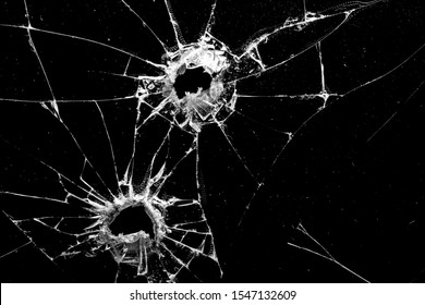 holes in the glass with cracks isolated on a black background