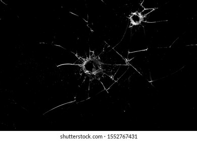 holes in the glass with cracks isolated on a black background