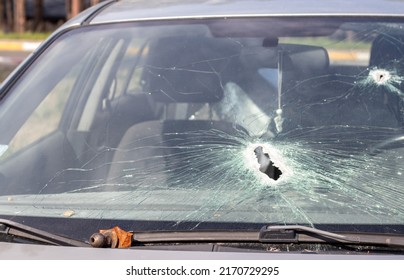 Holes On The Windshield Of The Car, It Was Shot From A Firearm. Bullet Holes. Smash Car Windshield, Broken And Damaged Car. The Bullet Made A Cracked Hole In The Glass. Ukraine, Irpen - May 12, 2022