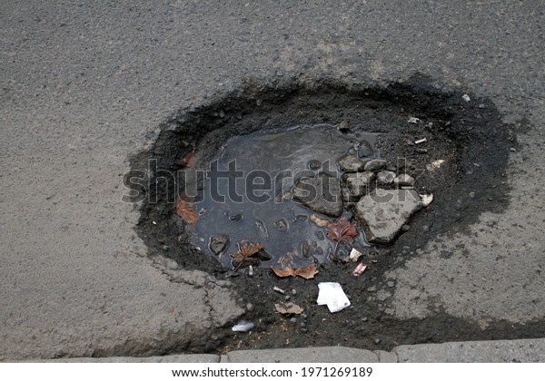 holes in the road,\
broken road surface