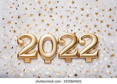 Holiday background Happy New Year 2021. Numbers of year 2022 made by gold candles on bokeh festive sparkling background. celebrating New Year holiday, close-up. Space for text