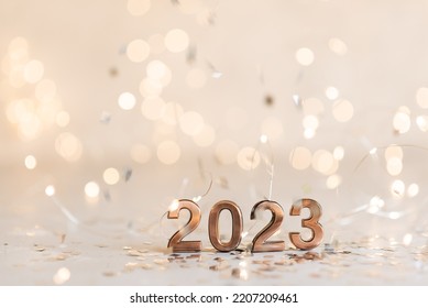 Holiday background Happy New Year 2023. Numbers of year 2023 made by gold candles on bokeh festive sparkling background. celebrating New Year holiday, close-up. Space for text - Shutterstock ID 2207209461