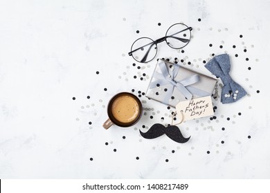 Holiday Breakfast On Happy Fathers Day With Cup Of Coffee, Gift Box, Glasses, Bowtie And Moustache Top View. Flat Lay.