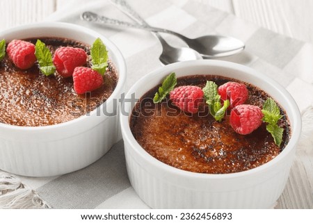 Holiday chocolate creme brulee with berry on top close-up in a ramekin on the table. Horizontal
