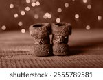 Holiday Christmas Baby Toy Small Boots on Wooden Table Background. Cozy Concept. Color of the Year 2025 Mocha Mousse color.