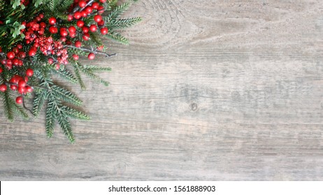 Holiday Christmas Background With Evergreen Pine Tree Needles And Red Winter Berries Over Wood Texture, Horizontal, Widescreen