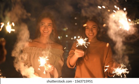 Holiday Concept. Asian Girls Playing Fun Fireworks On The Beach. 4k Resolution.