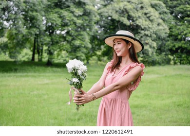 Holiday concept. Beautiful girl is getting flowers. Beautiful girl enjoys the scenery and nature.