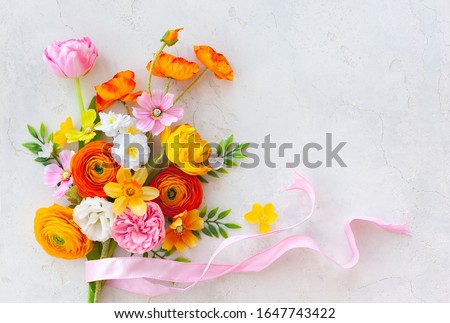 Holiday concept with bouquet of spring flowers on pastel vintage background. Easter composition, flat lay.