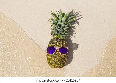 Holiday concept. Pineapple with sunglasses in a  Caribbean beach - Powered by Shutterstock